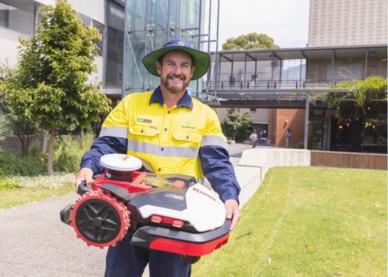 Horticulturist holding a robotic mower